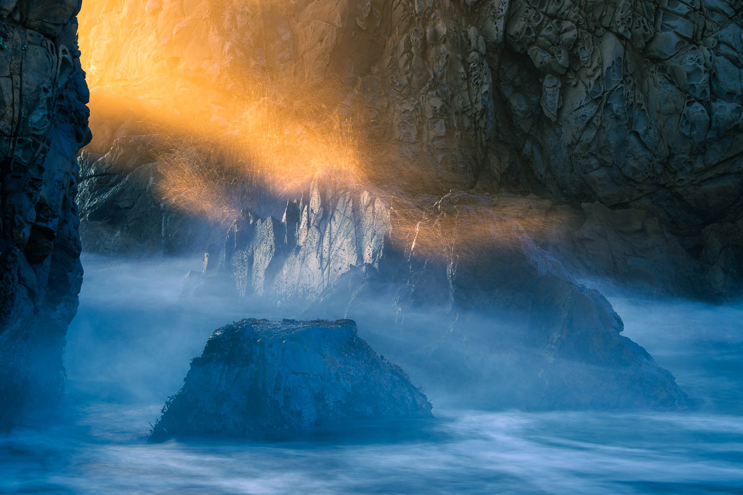 Fireworks at Sea Wave splashes lit with golden light along rocky coast