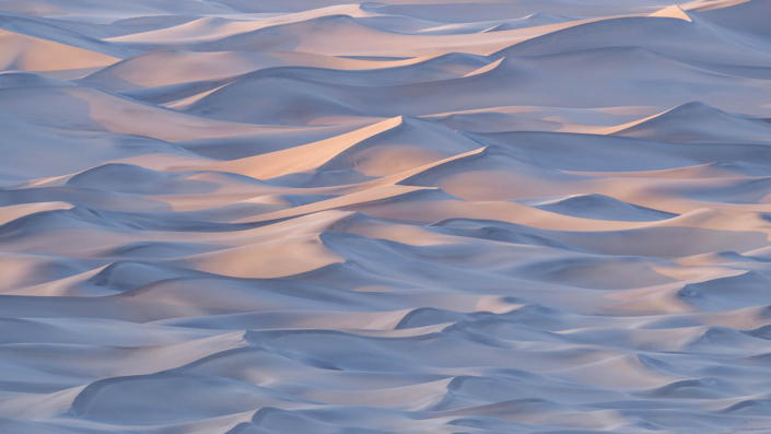 Undulating patterns of sand dunes at sunset in Death Valley